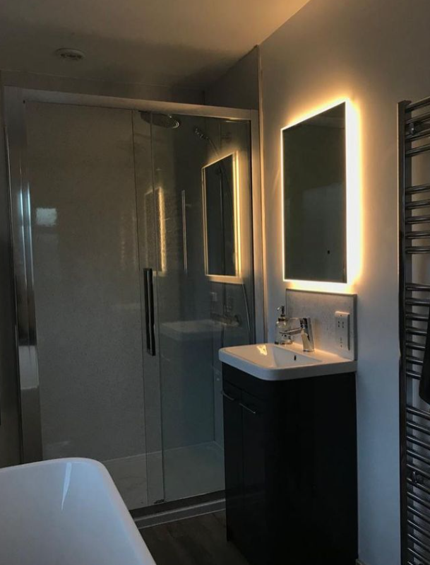 Backlit LED mirror and vanity lighting finishing a refurbished bathroom.